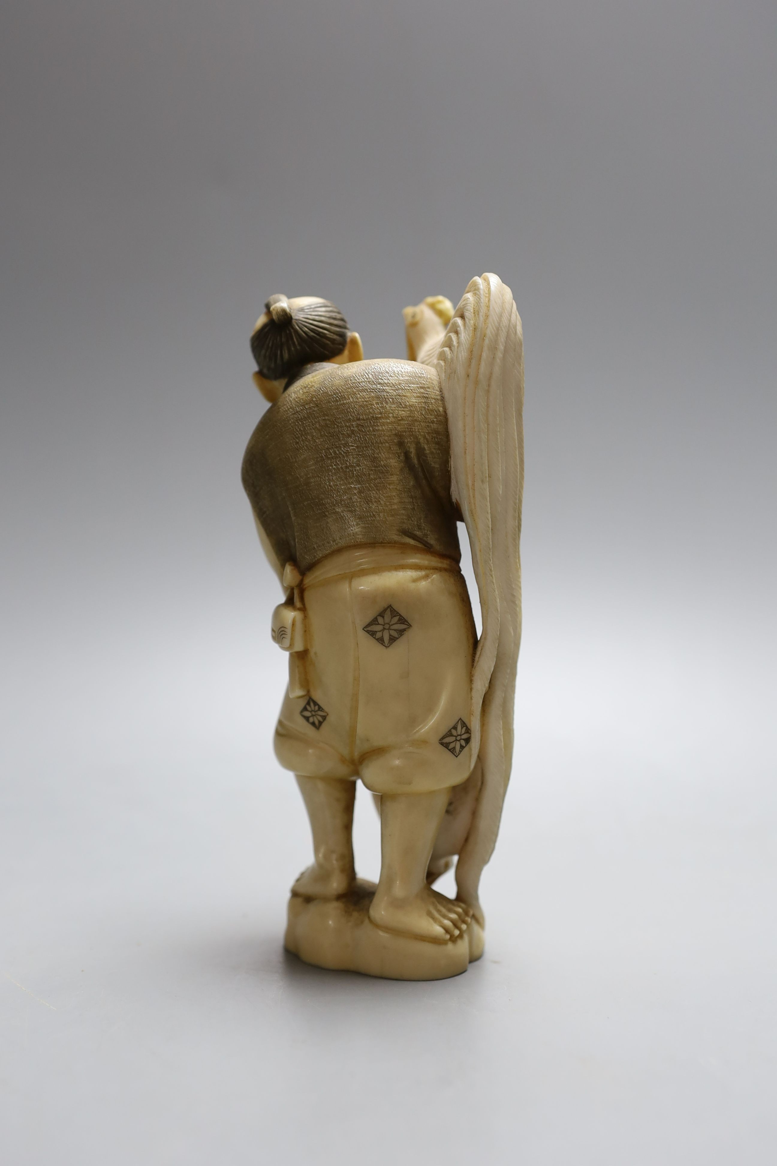 A Japanese ivory okimono figure of man with chicken, early 20th century, signed inset tablet to base - 16cm high